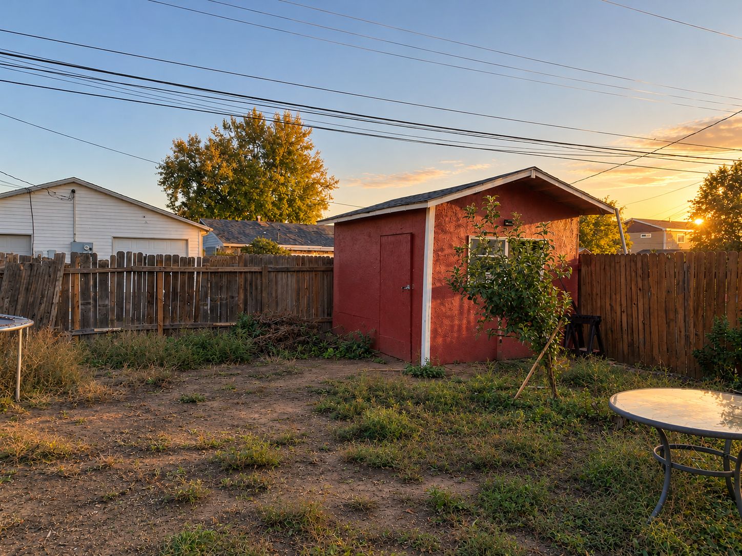 Fenced backyard with red storage shed